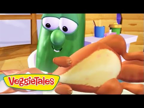 Green cucumber character from VeggieTales smiling as a hand holds a bread bun in a kitchen setting.