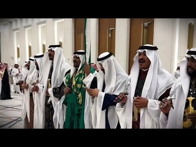 فرقة عرضة نجدية بالزي الموحد والسيوف والراية (رجال)