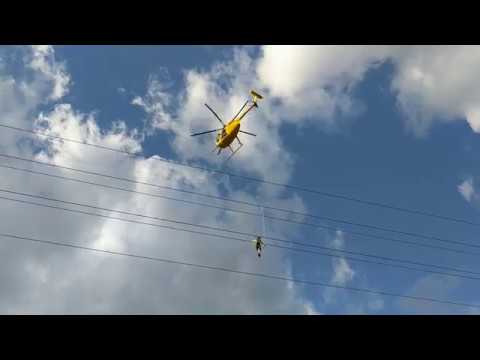 Guy Dangling from Helicopter works on Power Lines