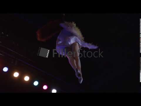 Woman acrobat performing with neck loop in the air