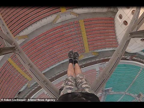 Terrifying moment British daredevil dangles from the rafters of the 262ft San Siro stadium in Milan