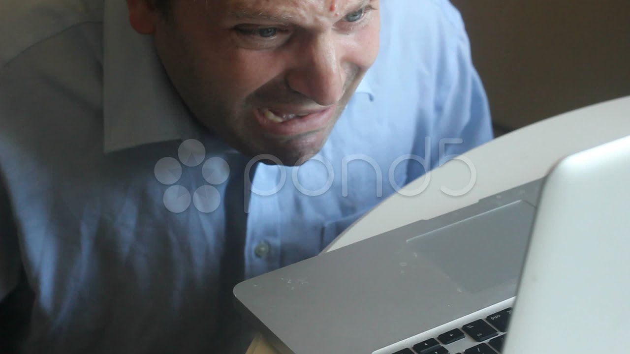 Frustrated Business Man Bites His Laptop. Stock Footage
