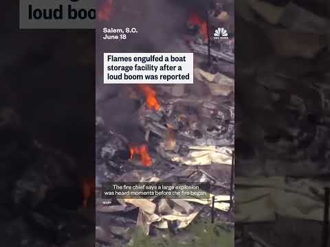 Flames engulfed a boat storage facility after a loud boom was reported