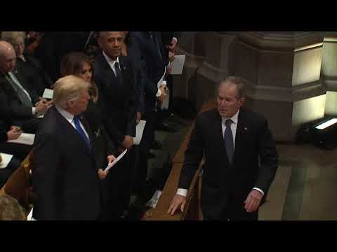 George W Bush sneaks candy to Michelle Obama at Bush funeral