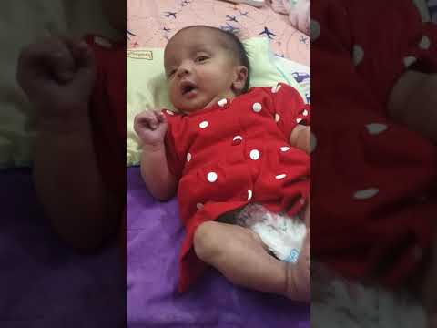 Aarvi showing chocolate to her 28days old sister