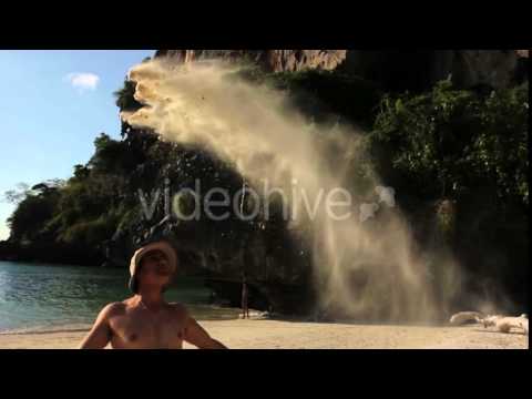Man Throwing up Sand on the Beach