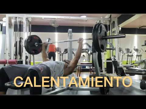 Calentamiento de pecho en banco plano con barra olímpica