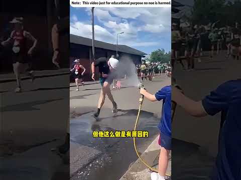 小男孩朝路過的運動員噴水
