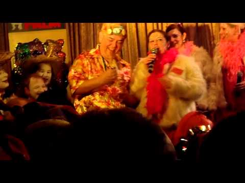 Frits Pelt krijgt van Och Enne een Barbie tijdens de GROEËTE BOETEGEWEUNE BINNEZITTING in cafe Pelt