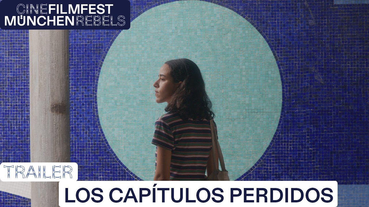 An image of a young woman against a blue wall with a circle pattern behind her.