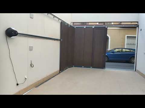 Puerta seccional de apertura lateral, imitación madera oscura. Instalación de motor techo lateral.