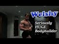 Seriously huge young bodybuilder flexing and posing after workout