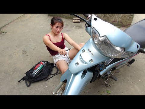 Girl repairs and restores motorbikes in the middle of the road - Restoring an old suzuki