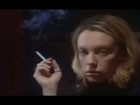 Velvet Goldmine 1998 trailer frame with glitter-smeared glam idol onstage under hot lights