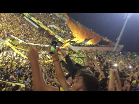"Entrada de los bombos bajo la bandera gigante (Peñarol vs Atlético Tucumán 2018)" Barra: Barra Amsterdam &bull; Club: Peñarol &bull; País: Uruguay
