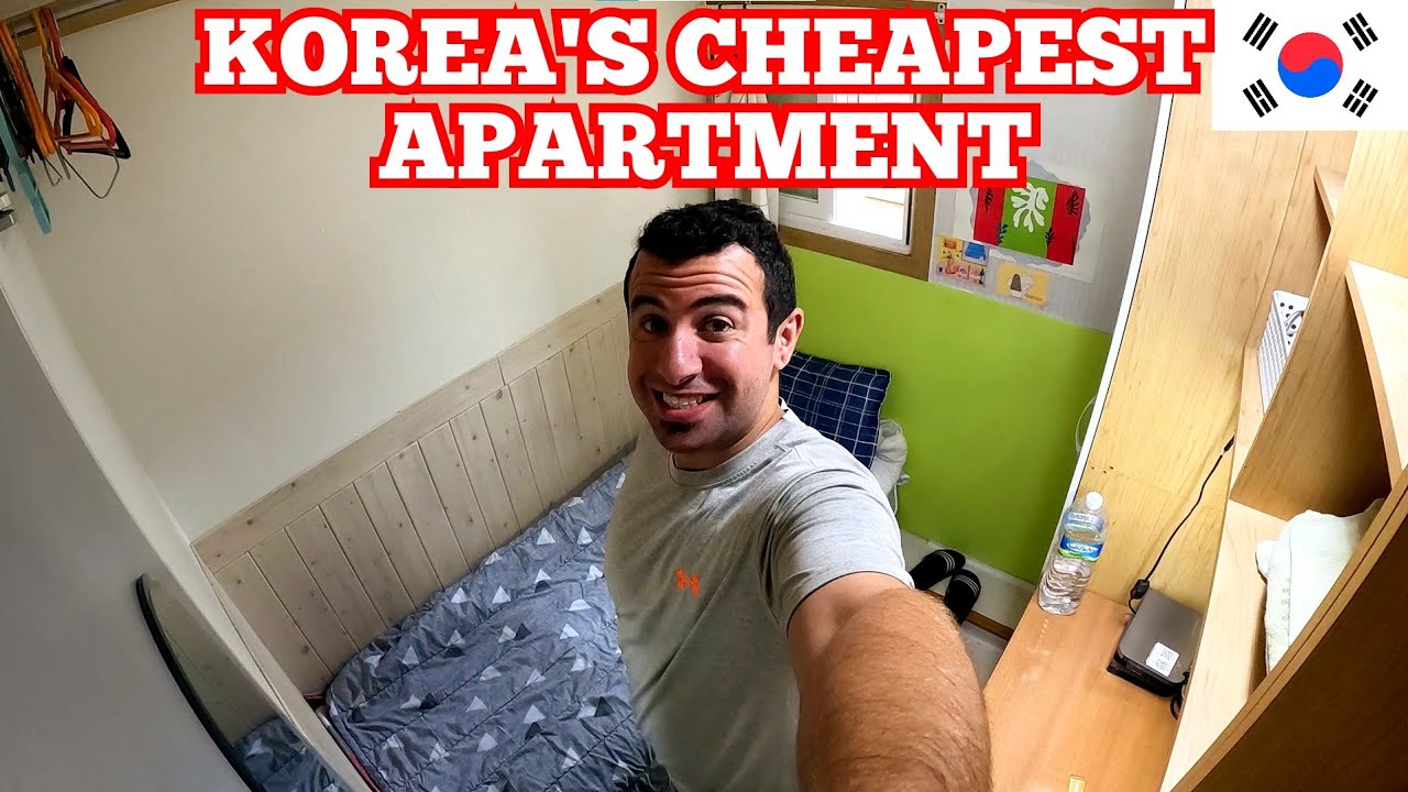 A tiny Korean gosiwon room interior showing a single bed wall-mounted desk and small window in the very compact studio apartment in Seoul