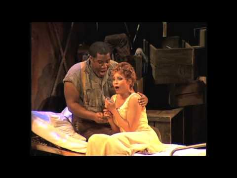 2010 stage-trailer frame suggesting the opera’s street-chorus energy that the album captures