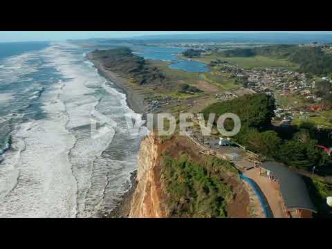 Aerial truck shot over the coastal waters of Puerto Saavedra, Araucania, Chile, bright blue sky day