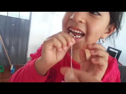 NIÑA SACÁNDOSE  SOLA EL DIENTE DE LECHE