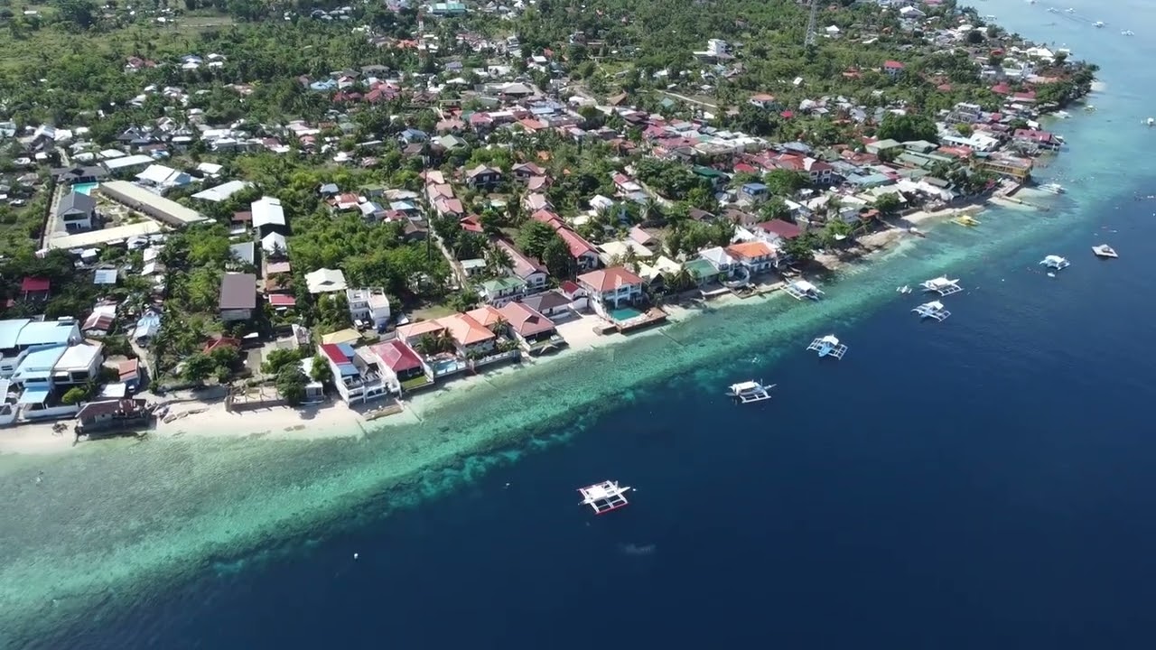 From above, Panagsama reveals its layered beauty - town, tide, and coral shelf.