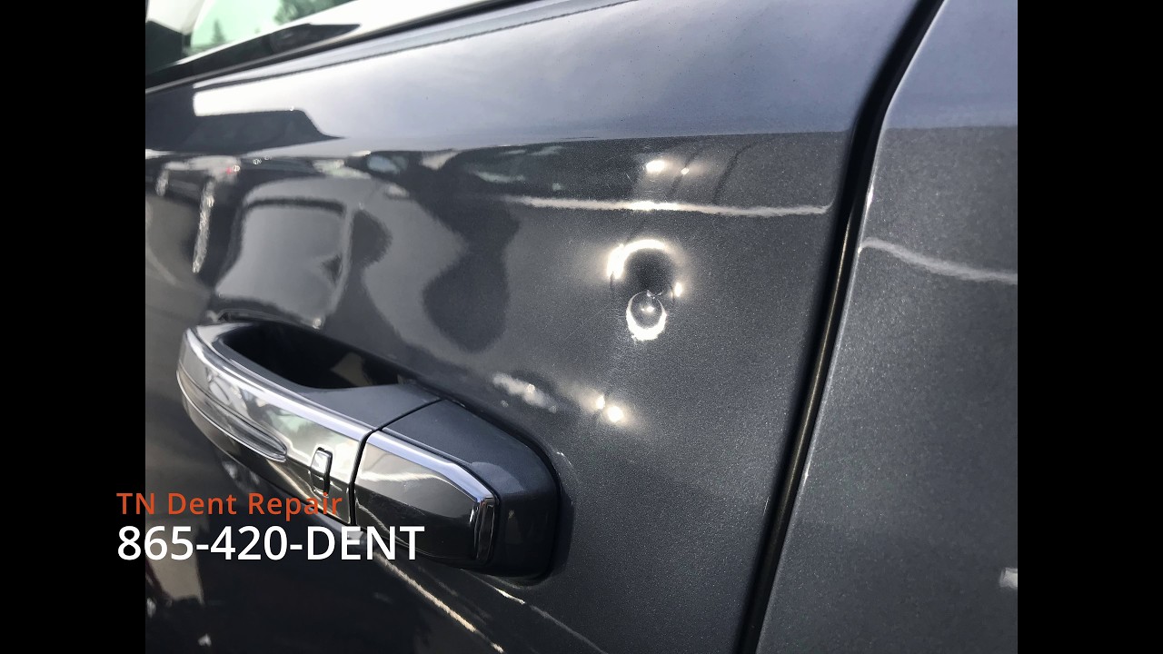 Thumbnail: deep stretched door dent on a Cadillac Escalade before paintless dent repair