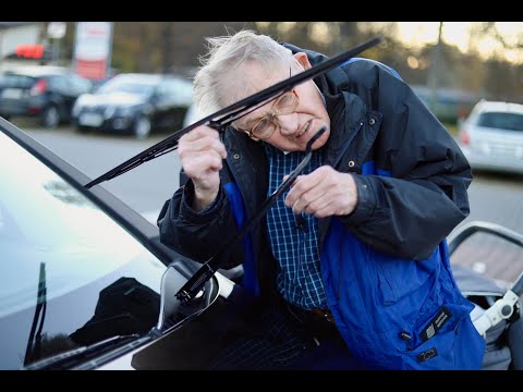 Wymienia wycieraczki na parkingu