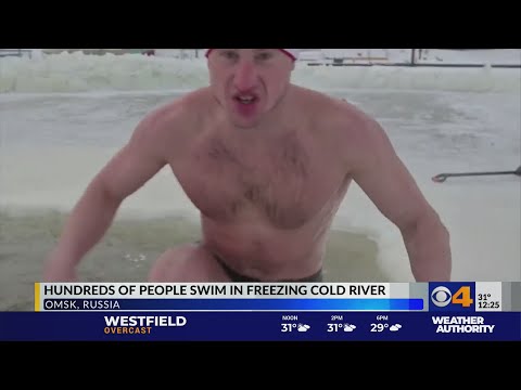 Hundreds of people swim in freezing cold river