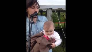 Jens Hult sjunger med en bebis i sin famn