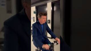 Rick Astley riding an electric scooter