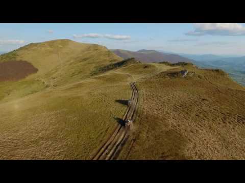 Suv Convoy Traveling Through the Mountains of the Carpathians. the Camera Flies Over the Trees and