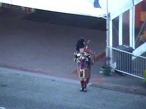 a bagpiper in scotland (view from a cruise ship)