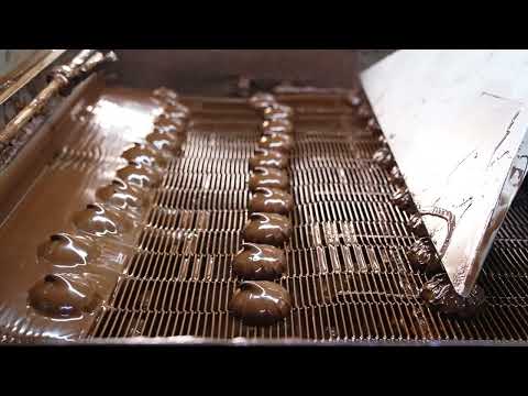 Zephyr candies covered with melted chocolates go under the flow of air.