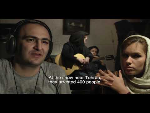 Trailer montage: rooftop strum at dusk, a shuttered door rolling down, and a band counting in as the camera pushes close