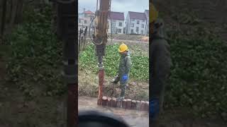 Hammer excavator driving wooden pile under water