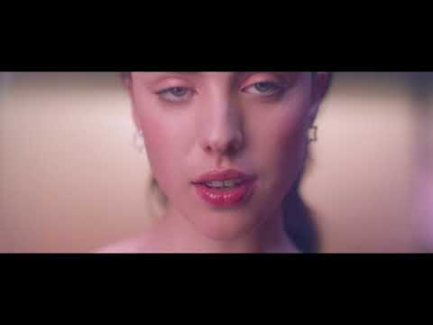 The Substance official trailer frame: neon-lit close-up of Demi Moore as Elisabeth Sparkle