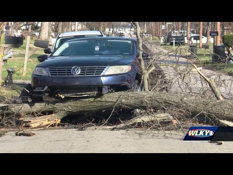 Neighbors work to clean up after high winds from Friday's storm cause severe damage