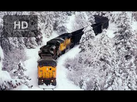 Powerful Train plows through snow covered railway tracks