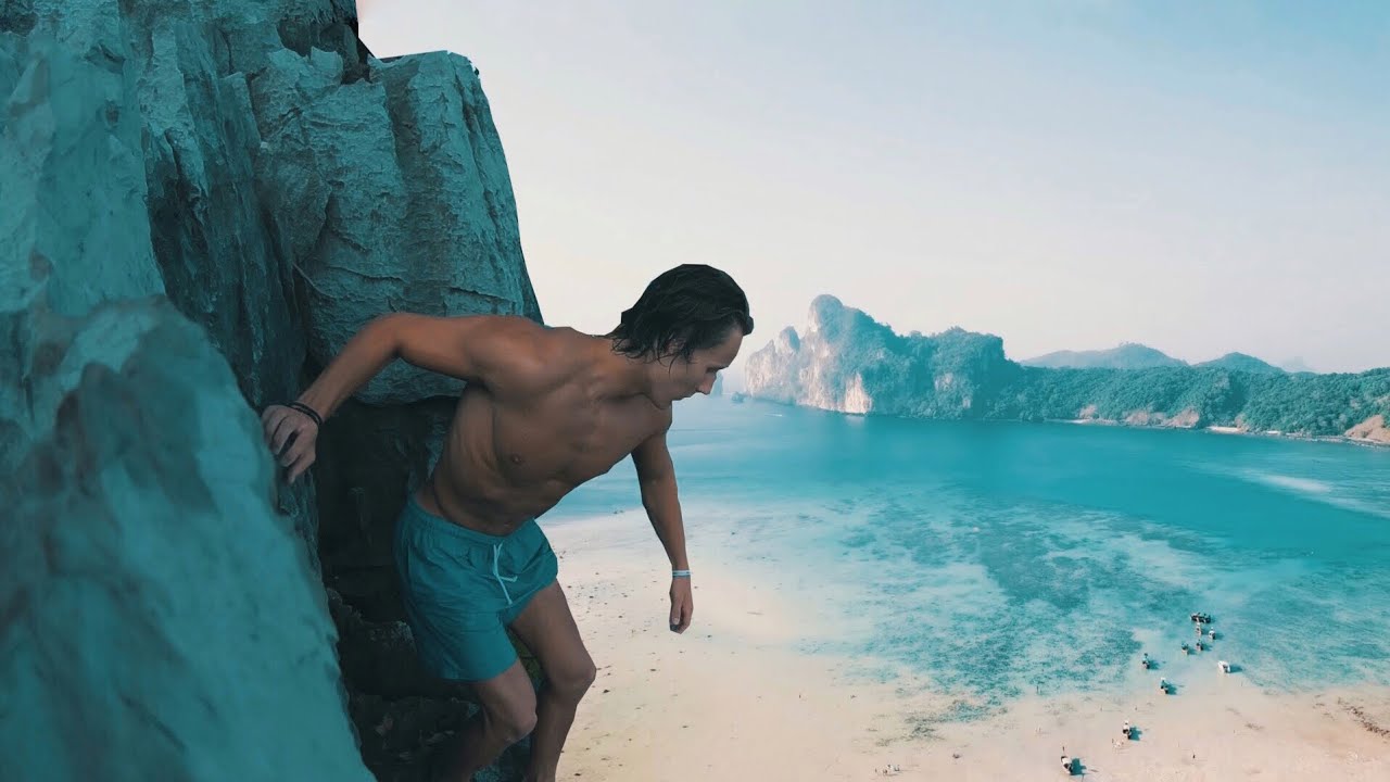 An adventurer experiences cliff jumping into crystal waters.
