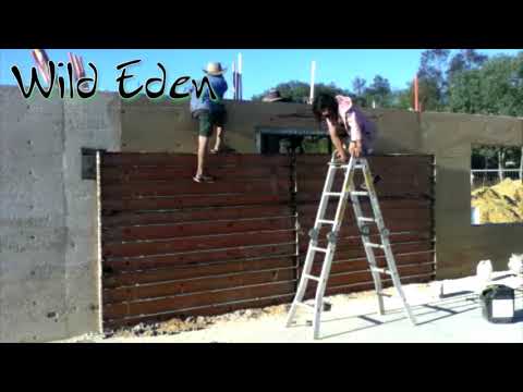 Family unveils a rammed earth wall with door opening. #teamwork! SRE Wild Eden