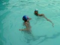 Three Girls Swim In Deep Pool