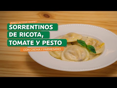 Sorrentinos de ricota, tomate y pesto, con crema y parmesano.