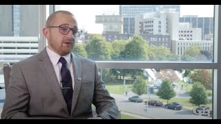 Gabe Hutton dressed in a suit and tie sitting during the interview in his office building.