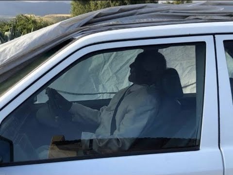 Man buried in his trusty Mercedes Benz with his hands on the steering wheel
