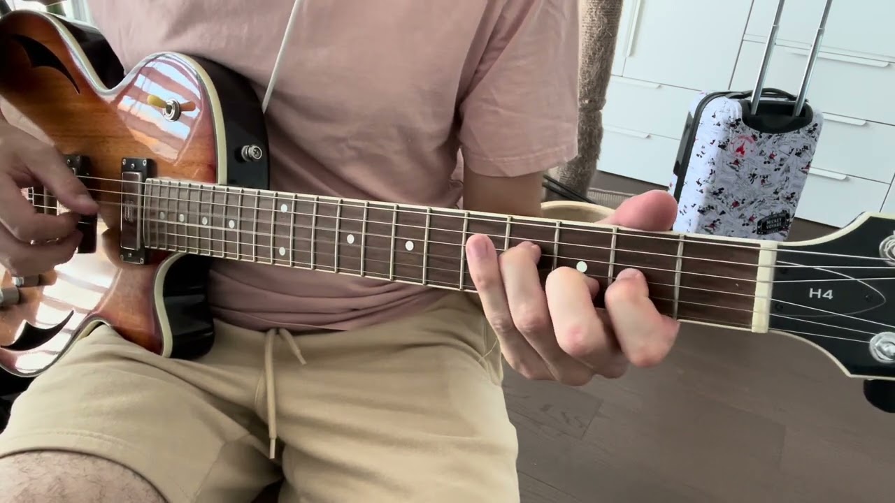 Hands fingerpicking the Solsbury Hill intro riff on an acoustic guitar in 7/8 time