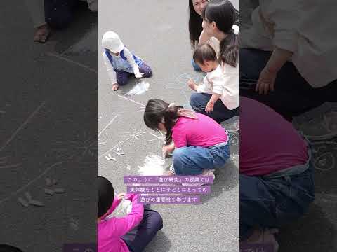松山東雲女子大学子ども専攻の専門科目「遊び研究」という授業の紹介です。今回の授業では、キャンパス内に併設されている認定こども園の園児たちと通路にお絵描きをしました。