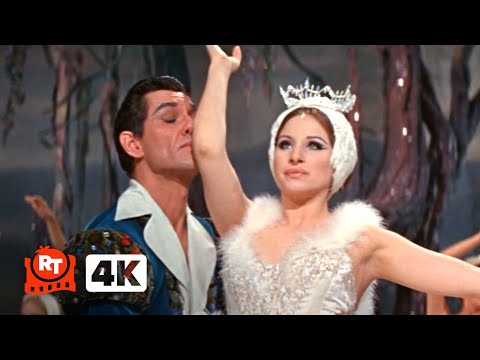 Η Barbra Streisand [Μπάρμπρα Στράιζαντ] ως Fanny Brice [Φάννυ Μπράις] στο κωμικό νούμερο «The Swan» από την ταινία Funny Girl [Αστείο κορίτσι] (1968) του William Wyler [Ουίλλιαμ Ουάιλερ]. Η σκηνή παρωδεί το κλασσικό μπαλέτο Η λίμνη των κύκνων του Πιότρ Ιλίτς Τσαϊκόφσκι [Pyotr Ilyich Tchaikovsky], ανατρέποντας κωμικά τη λυρική χάρη του πρωτοτύπου μέσα από την αδέξια, ξεκαρδιστική ερμηνεία της πρωταγωνίστριας.