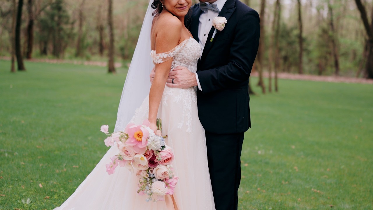 Bride and groom in a green garden with a spring bouquet