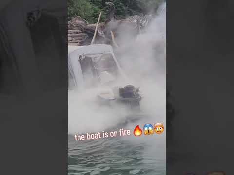 Boat engine is on fire and people are trying everything to put it out!