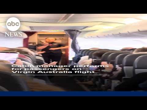 Cabin manager performs for passengers on Virgin Australia flight