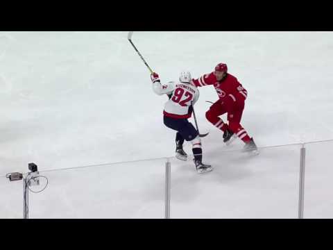 Evgeny Kuznetsov dekes the puck between Ron Hainsey's legs